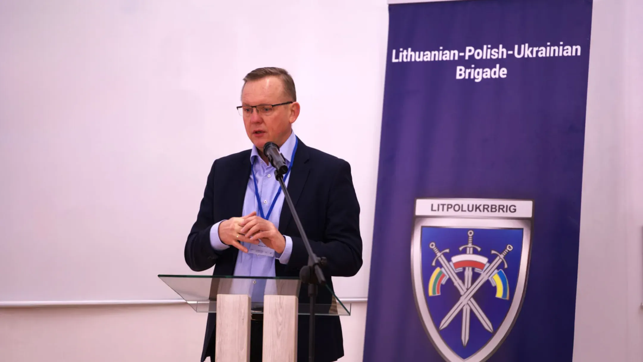 Пол Йонсон виступає на тлі банера Lithuanian-Polish-Ukrainian Brigade