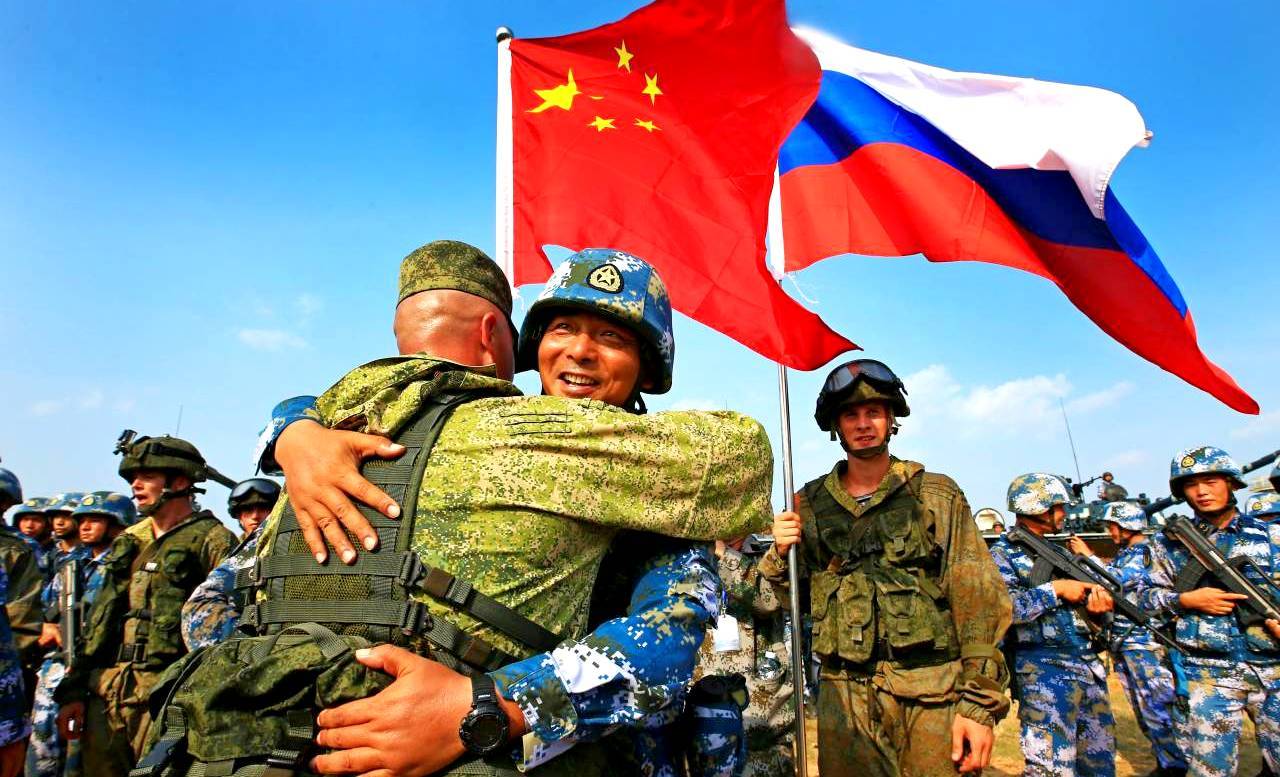 Російські та китайські військові обіймаються під прапорами двох країн