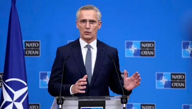Єнс Столтенберг виступає щодо ролі США в НАТО на тлі прапорів Альянсу