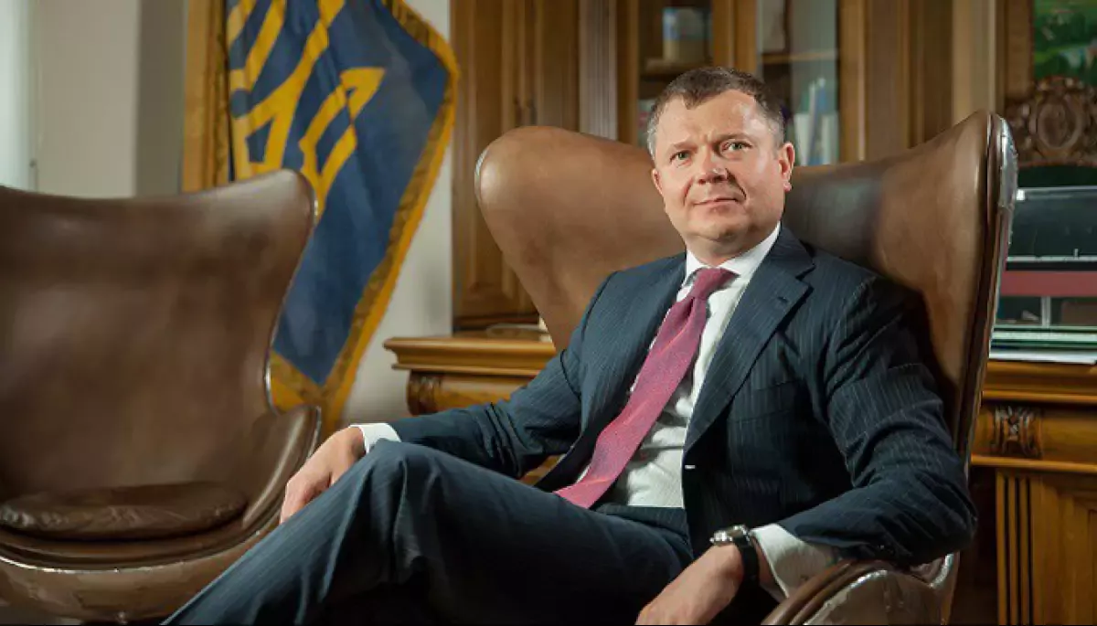 Константин Жеваго в костюме в кабинете с флагом Украины