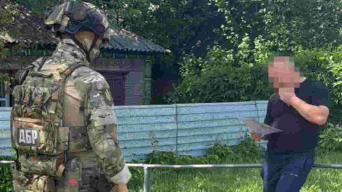 Працівник ДБР у формі розмовляє з цивільним під час розслідування