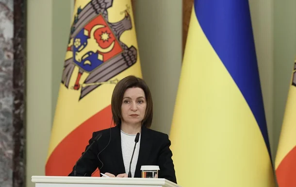 Жінка за трибуною на тлі прапорів Молдови та України