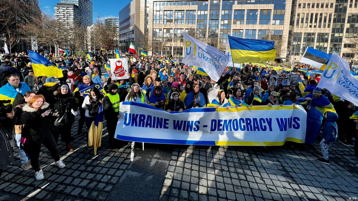 Протестувальники з прапорами України на марші в Брюсселі з банером Ukraine Wins - Democracy Wins