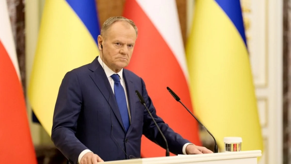 Дональд Туск за трибуною на тлі прапорів Польщі та України