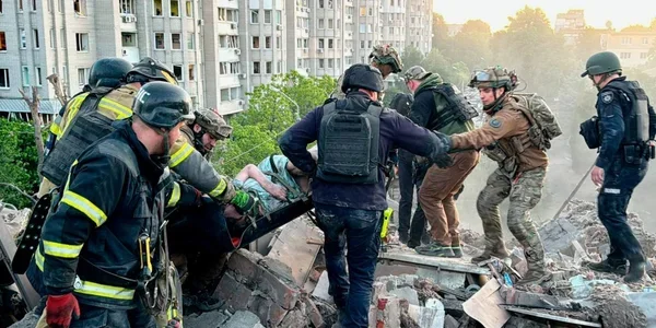 Рятувальники несуть постраждалого на ношах з руїн після атаки РФ у Дніпрі
