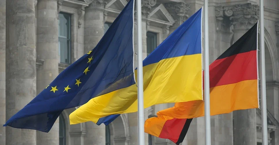 Прапори ЄС, України та Німеччини перед будівлею європейських інституцій
