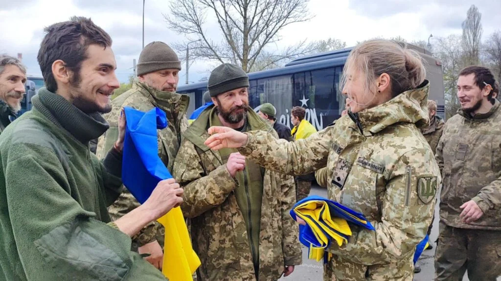 Звільнені захисники з прапором України після обміну полоненими