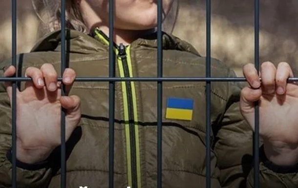 Українська дитина за ґратами з прапором на куртці