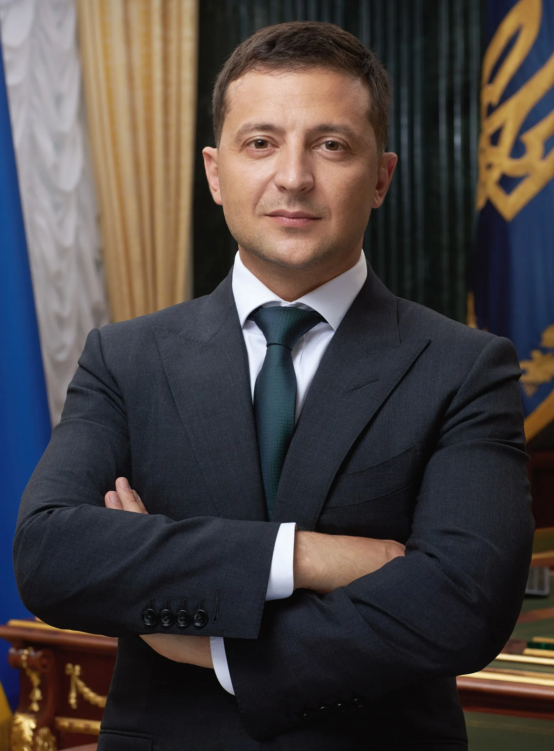 Офіційний портрет Володимира Зеленського в темному костюмі зі схрещеними руками