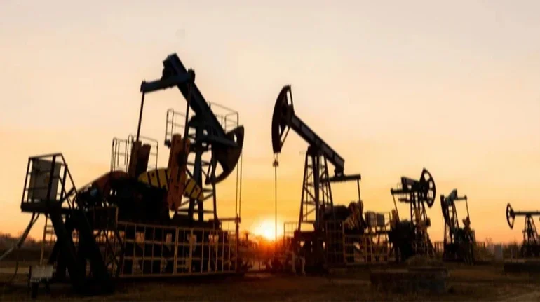Силуети нафтових качалок на тлі заходу сонця на родовищі