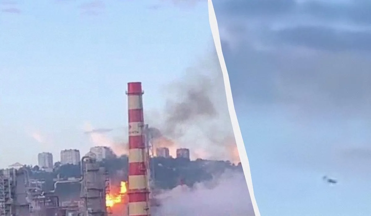 Пожежа біля смугастої промислової труби з густим димом на фоні міста