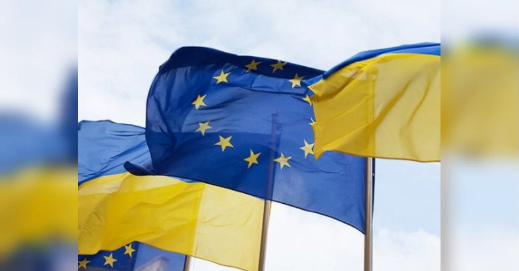 Прапори ЄС і України розвиваються разом на фоні блакитного неба