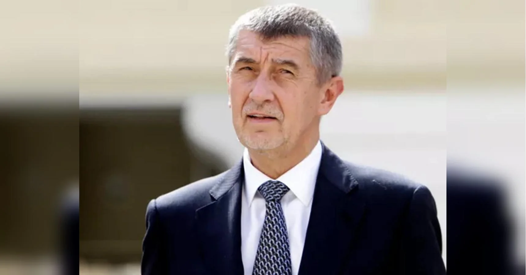 Андрій Бабіш у темному костюмі з візерунчастою краваткою дивиться вбік